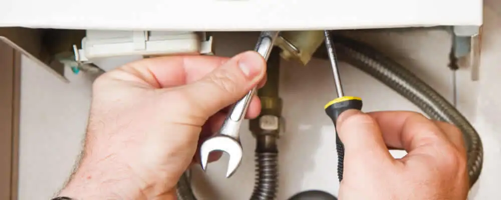 Boiler repair technician tightening pipe fittings and connections in Providence, RI
