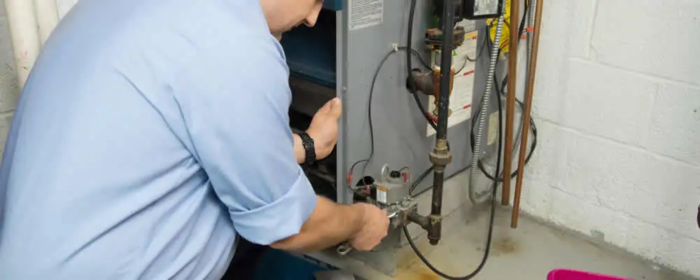 Furnace repair technician inspecting and servicing a home heating system in Providence, RI