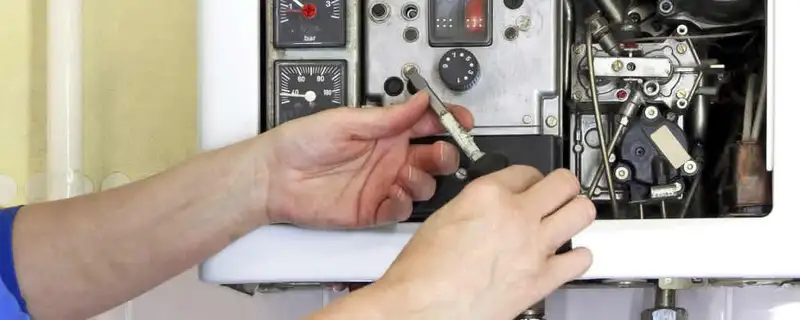 Heating repair technician adjusting boiler controls and components in Providence, RI