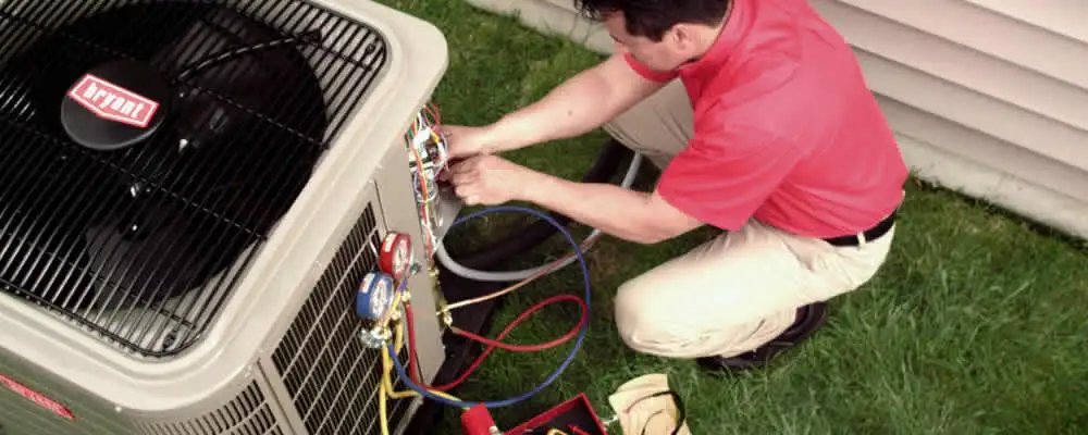 HVAC technician servicing an outdoor air conditioner unit in Providence, RI