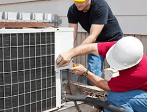 HVAC technicians repairing an outdoor AC unit on a rooftop in Providence, RI