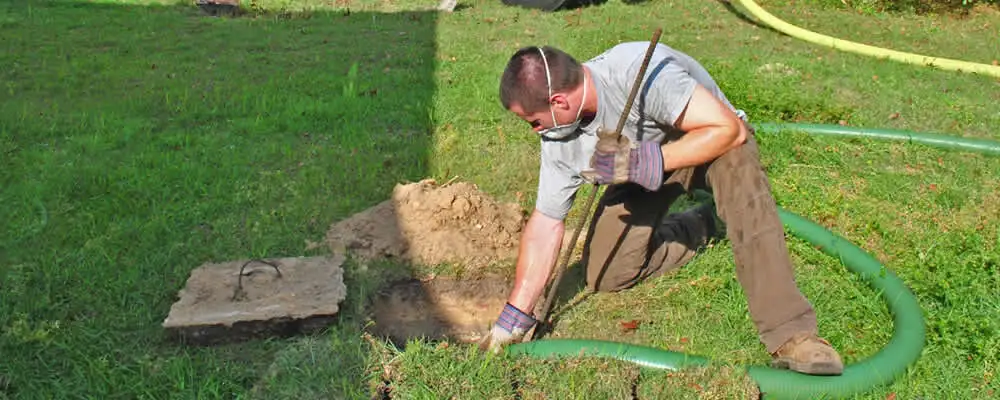 Septic pumping technician servicing a residential septic tank in Providence, RI