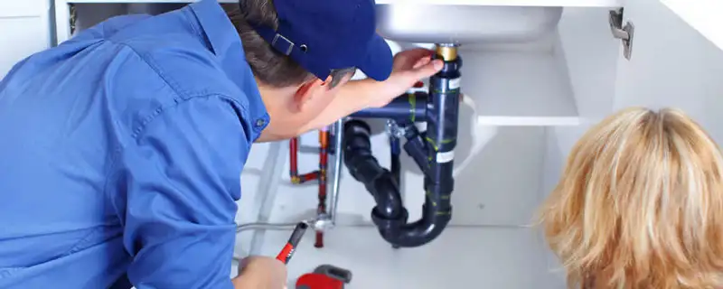 Plumber repairing under-sink drain pipes and fittings in Providence, RI